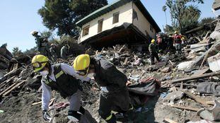 Chilean firemen drag articles of clothing from the rubble left by a massive earthquake and ensuing tsunami, in Constitucion March 4, 2010. Chile will need international loans and three or four years to rebuild after Saturday's 8.8-magnitude earthquake killed more than 800 people and ravaged its infrastructure, President Michelle Bachelet said. REUTERS/Ivan Alvarado (CHILE - Tags: DISASTER)
