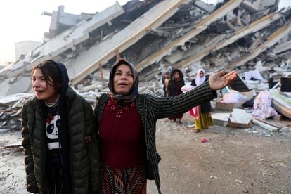 Varias mujeres lloran junto a los restos de un edificio derrumbado en la ciudad turca de Hatay, este martes.