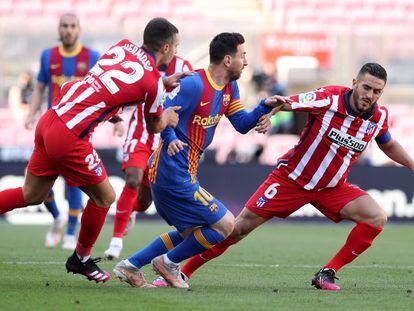 Messi trata de regatear a Mario Hermoso (izquierda) y Koke este sábado en el Camp Nou.