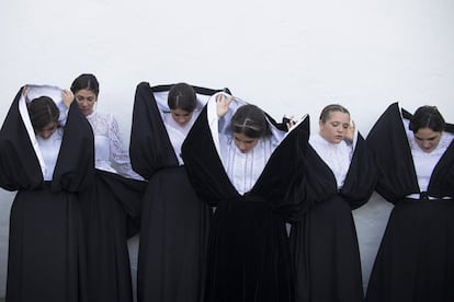 Hay quien piensa que en su origen el traje estaba reservado a las clases altas, cuyas mujeres deseaban mantener un color de piel blanquecino para diferenciarlas de aquellas que, por pertenecer a clases más populares, se veían obligadas de trabajar de sol a sol.