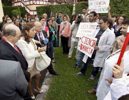 La Secretaria de Estado de Investigación, a la izquierda, con chaqueta blanca, responde a un a grupo de científicos que protesta por los recortes en Santander.