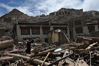 Un monje budista camina entre los escombros de unos edificios arrasados por las inundaciones en la región de Leh, al norte de India.