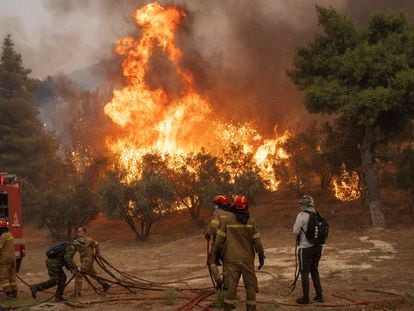 Bomberos y voluntarios se enfrentan a un gran incendio en Hasia, cerca de Atenas, el pasado martes.