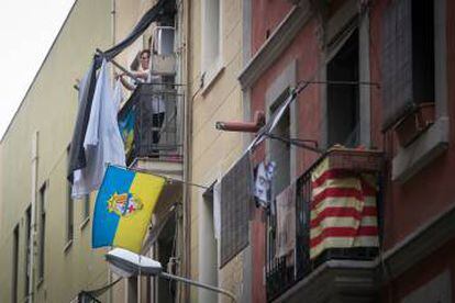 Una dona estén la roba al balcó de casa seva, a la Barceloneta.