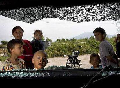 Niños rumanos miran un coche destrozado cerca de Nápoles.