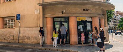 Varias personas hacen cola en una oficina de empleo en Palma de Mallorca. 
