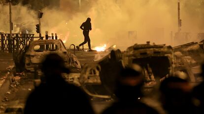 Un manifestante corre en una calle del suburbio parisiense de Nanterre, durante las protestas por la muerte del joven Nahel por un disparo policial, el 30 de junio de 2023.