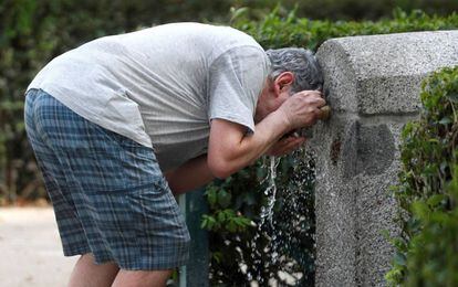 Un hombre se refresca en una fuente de un parque de Madrid el 3 de julio.