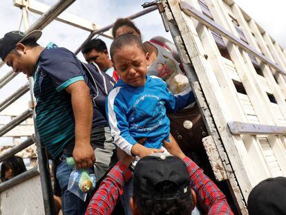 Un niño hondureño llora al bajar de un camión de la caravana. 