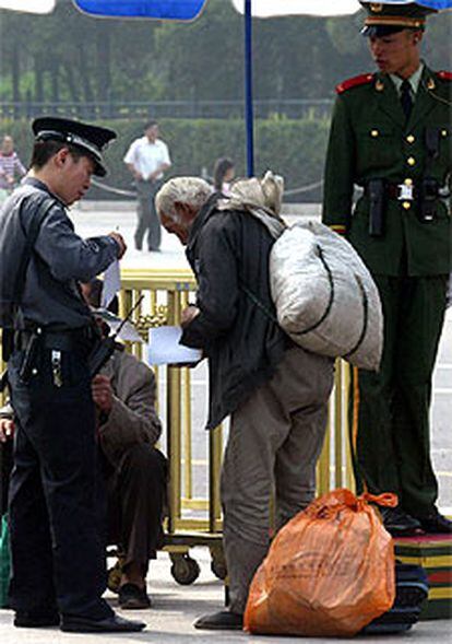 Un anciano, ante un control policial en la plaza de Tiananmen.