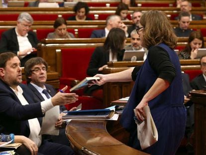 La diputada de la CUP Eulàlia Reguant le regala el libro "L'hora dels voltors", de Josep Manel Busqueta, al vicepresidente Oriol Junqueras durante el Pleno de los Presupuestos.