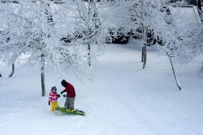 Un padre y su hija disfrutan de la nieve en Cabeza de Manzaneda (Ourense), el sábado.