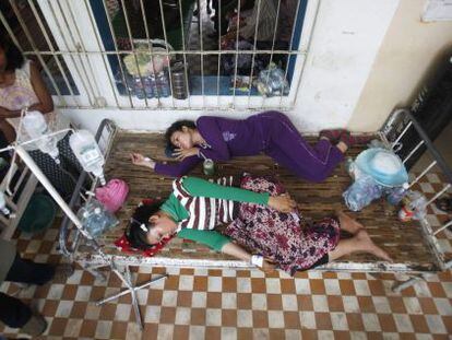 Dos trabajadoras camboyanas heridas descansan en el hospital tras el desplome de una planta de la empresa textil en la que trabajan.