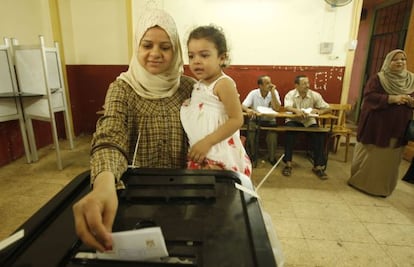 Una mujer vota con su hija en brazos en El Cairo.