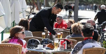 Un camarero atiende a los clientes en una de las terrazas de los bares en las calles de Madrid.