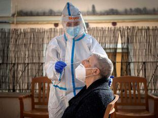 GRAFCAT4346. BARCELONA, 13/11/2020.- Una profesional sanitaria del Centro de Atención Primaria (CAP) de Horta realiza un test PCR a una residente de la Residencia Campoamor, este viernes, cuando Cataluña ha sumado 2.918 nuevos contagios de COVID-19, casi 900 menos que ayer, y otros 71 fallecidos notificados en las últimas 24 horas, mientras sigue cayendo la velocidad de transmisión del virus (Rt), que se ha situado en 0,85, dos centésimas menos que ayer, lo que empieza a repercutir en una estabilización de la presión hospitalaria. EFE/Enric Fontcuberta.