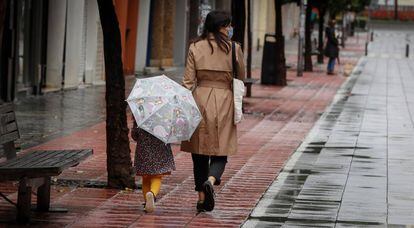 Una madre pasea con su niña por la calle Asunción de Sevilla. 