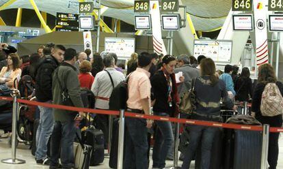 Pasajeros ante los mostradores de Iberia en Barajas