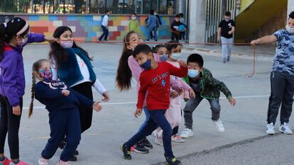 Niños con mascarilla en los patios del colegio Aura, en Terrassa.
