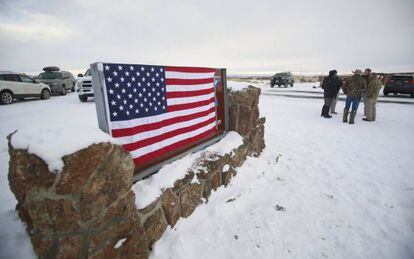 Los manifestantes han cubierto la señal del refugio con la bandera de Estados Unidos.