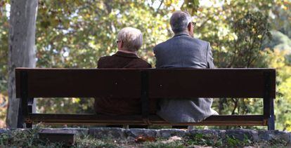 Dos ancianos sentados en un banco de un parque público de Madrid.
