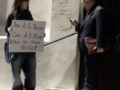 Una indignada del 15-M espera con un cartel a las puertas del Oratorio de San Felipe Neri en C&aacute;diz, a que salga el presidente de la Conferencia Episcopal Espa&ntilde;ola Antonio Rouco Varela.
 