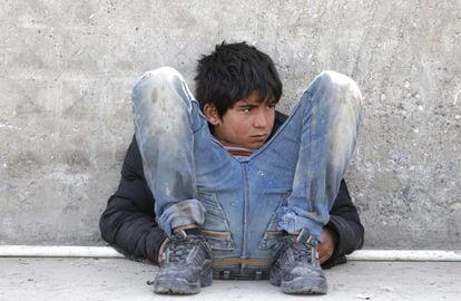 Un niño refugiado sirio espera sentado en el suelo junto a un acceso fronterizo en la ciudad de Kilis (Turquía).