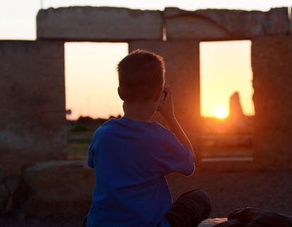 Un niño observa cómo se pone el sol en una réplica de las piedras de Stonehenge, en la Universidad de Texas, Estados Unidos.
