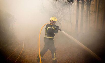 Un bombero trabaja este domingo en el incendio de Pazos de Bordén (Pontevedra).
