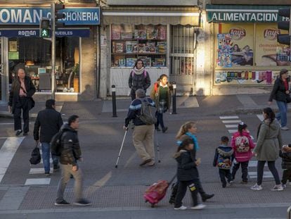 Viandantes cruzan una calle de Usera, en el sur de la ciudad de Madrid.