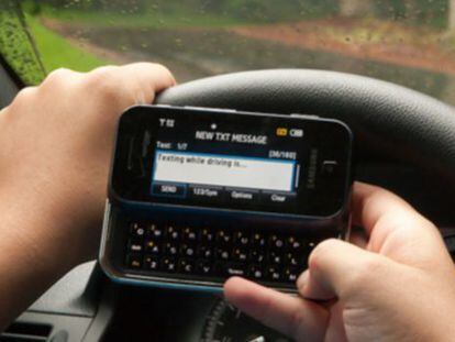Un conductor escribe un mensaje de móvil mientras conduce.