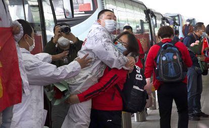 A medida que la epidemia se retira, vuelven los gestos de cariño. Una sanitaria de la provincia china de Jilin que acudió como refuerzo a la ciudad se despide con un abrazo de uno de sus compañeros de trabajo en Wuhan a las puertas del aeropuerto internacional Tianhe.