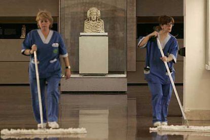 Dos trabajadoras limpian la sala de Arte Ibérico del Museo Arqueológico Nacional, cuya pieza estrella es la Dama de Elche, qeu se ve al fondo.