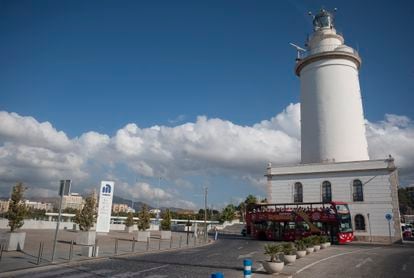 Un autobús turístico pasa frente a La Farola para que los visitantes puedan ver de cerca el histórico faro malagueño.