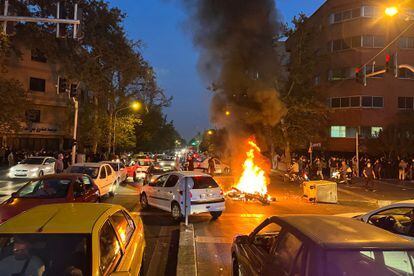 Las protestas callejeras han ido a la par de una movilización, más intensa, en las redes sociales. La etiqueta de Twitter #MahsaAmini ha alcanzado ya casi 2 millones de menciones en esa red social, de acuerdo con la agencia Reuters. En la imagen, una motocicleta en llamas durante las protestas en el centro de Teherán, este lunes por la noche.  