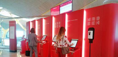Dos viajeras tramitan su tarjeta de embarque en el área dedicada al Puente Aéreo en el aeropuerto de Madrid-Barajas.