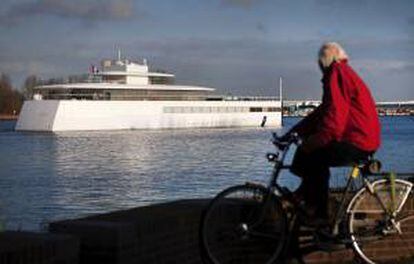 Un hombre que pedalea en su bicicleta observa como el yate ordenado construir por el cofundador de Apple Steve Jobs, compite en una regata cerca de Velsen, Holanda. EFE/Archivo