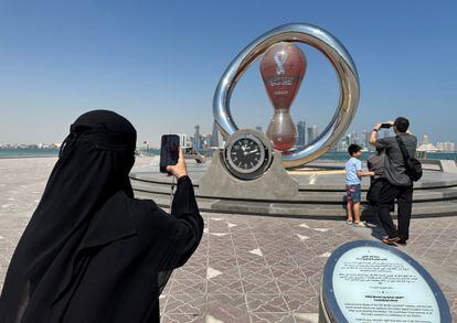 Una mujer toma una fotografía ante el reloj de la cuenta atrás para el inicio del Mundial de Qatar. 