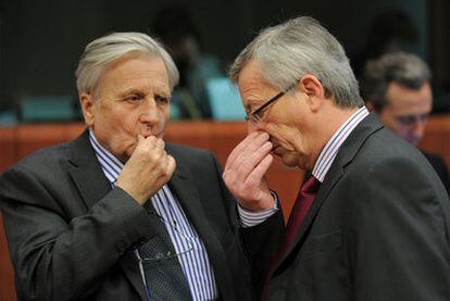 Trichet (izquierda) medita junto a Juncker, en la cumbre de la UE de ayer.