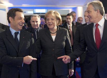 De izquierda a derecha, Nicolas Sarkozy, Angela Merkel y Tony Blair abandonan el encuentro celebrado en París.