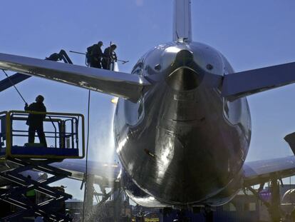 Varios operarios lavan un avi&oacute;n Boeing.