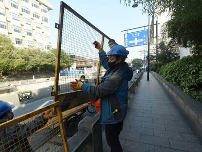 Trabajadores de Hangzhou instalan vallas en las carreteras para impedir la movilidad y hacer frente a la expansión del coronavirus.