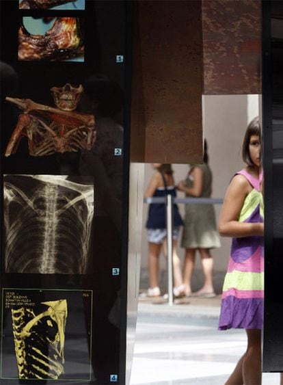 Una niña observa una de las radiografías que muestran la constitución de Ötzi.
