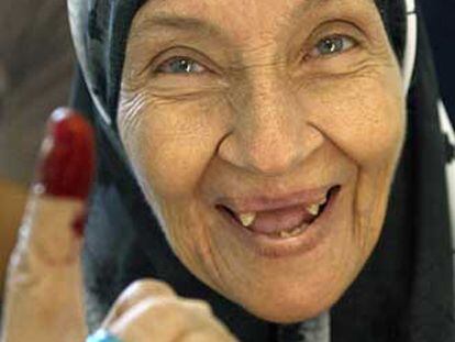 Una mujer muestra su dedo tintado tras votar ayer por Mubarak.