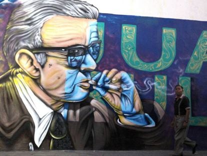 Un hombre pasea frente a un mural con una imagen de Juan Rulfo en Tuxcacuesco (México).