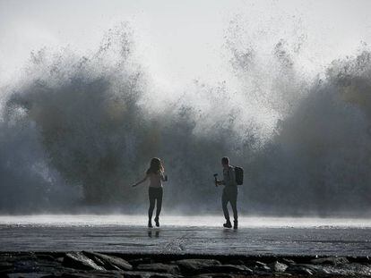 Una pareja intenta hacer una foto en la playa de Barcelona.