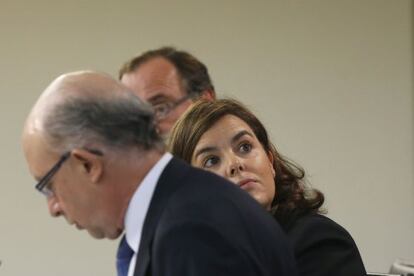 Soraya Sáenz de Santamaría, amb els ministres d'Hisenda, Cristóbal Montoro , i Sanitat, Alfonso Alonso (darrere), durant la roda de premsa posterior a la reunió del Consell de Ministres celebrada al Palau de la Moncloa.