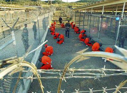 Varios soldados estadounidenses vigilan a presos talibanes y de Al Qaeda en la base de Guantánamo, en enero de 2002.