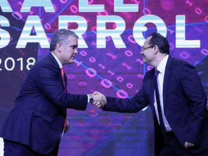 El mandatario colombiano, Iván Duque, estrecha la mano a Luis Carranza, presidente ejecutivo de CAF.