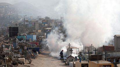 Trabajadores fumigan con vapor un cementerio en Lima.